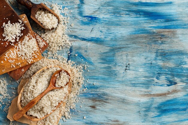 Celtycka szara sól morska z łyżką na niebieskim drewnianym stole