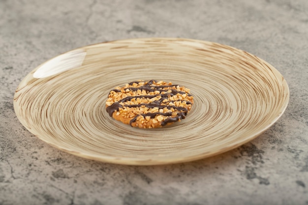 Zdjęcie ceramiczny talerz glazurowanych ciastek owsianych na kamiennym stole.