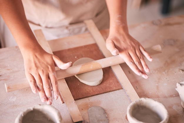 Ceramika i projektowanie ceramiki rękami kobiety w pracowni warsztatowej do tworzenia form i sztuki Rzeźba z gliny i produkcja z dziewczyną rzemieślnikiem toczącym się po stole do rękodzieła i hobby