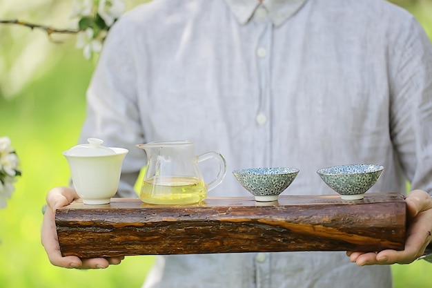 ceremonia parzenia herbaty, azjatycki mistrz herbaty przygotowuje świeżą wiosenną zieloną herbatę w ogrodzie