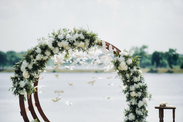 Ceremonia ślubna na ulicy na zielonym trawnikuDekoruj łuki ze świeżych kwiatów na uroczystość