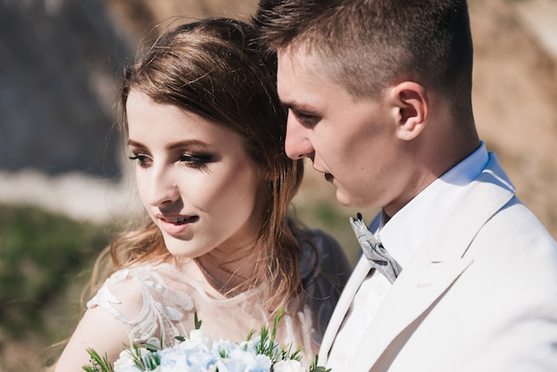 Ceremonia ślubna w górach. Narzeczeni stojący przed piaszczystymi górami. Szczęśliwa para, piękny ślub w malowniczej okolicy