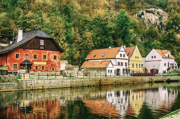 Cesky Krumlov - słynne czeskie historyczne piękne miasto, widok na rzekę miejską i piękną jesienną ulicę z kolorowymi budynkami i jesiennymi drzewami. Podróżuj po Europie