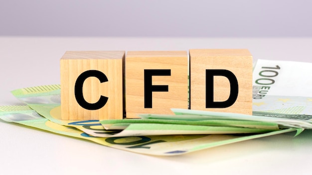 CFD akronim Kontrakty różnicowe tekst na drewnianych kostkach z euro rachunkami