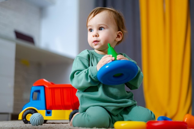 Ch?opiec bawi si? jego kolorowe zabawki na pod?odze w domu Dziecko z zabawkami edukacyjnymi Wczesny rozwój