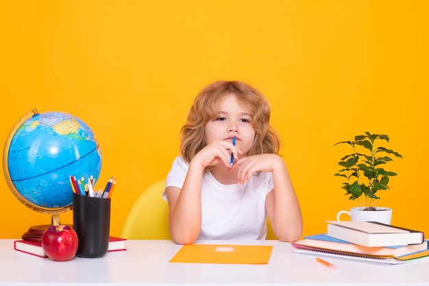 Ch?opiec Kid ze szko?y podstawowej z ksi??k? na ?ó?tym tle odizolowane Mały uczeń inteligentny nerd uczeń gotowy do nauki Pojęcie edukacji i uczenia się