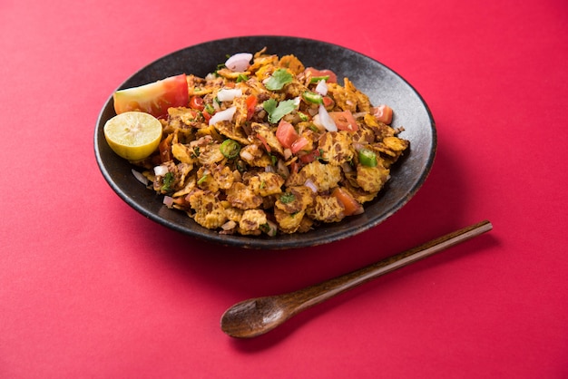 Chana chor jor garam - indyjskie pikantne pogawędki lub przekąski podawane w talerzu lub misce na kolorowym lub drewnianym tle. Selektywne skupienie