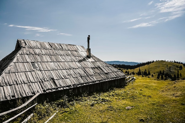 Chata górska lub dom na wzgórzu Velika Planina alpejski krajobraz łąki Rolnictwo ekologiczne Cel podróży dla rodzinnych wędrówek Alpy Kamnickie Słowenia Wielki Płaskowyż