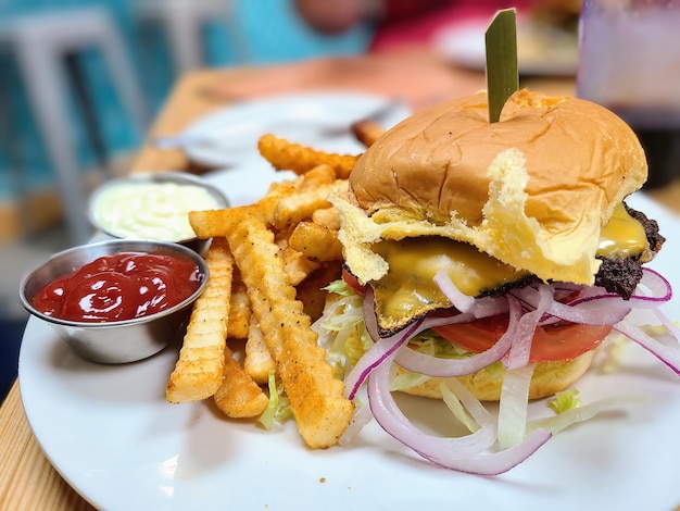 Cheeseburger z frytkami i przyprawami w zwykłej restauracji