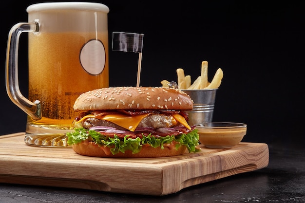 Cheeseburger z kotletem wieprzowo-cielęcym, boczkiem, świeżymi warzywami podawany z bursztynowym piwem, frytkami i aioli