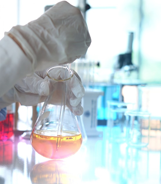 Chemia pracująca z żółtym płynnym szkłem laboratoryjnym