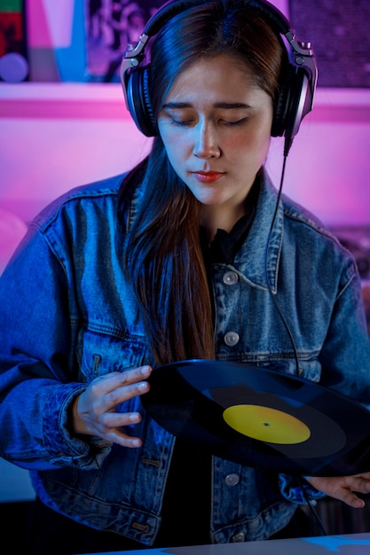 Chica latina sosteniendo un disco de vinilo en sus manos Concepto de chica dj en tienda de discos