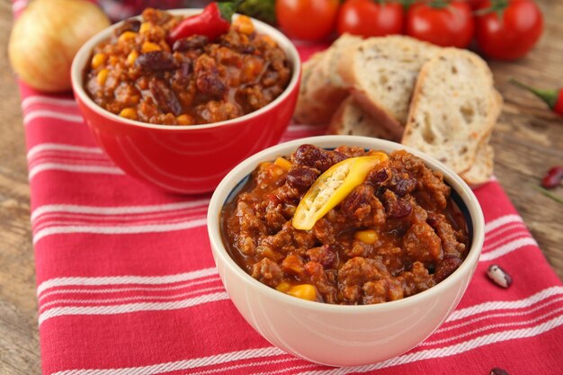 Chili con carne ze świeżą papryką w miseczkach na szmatce