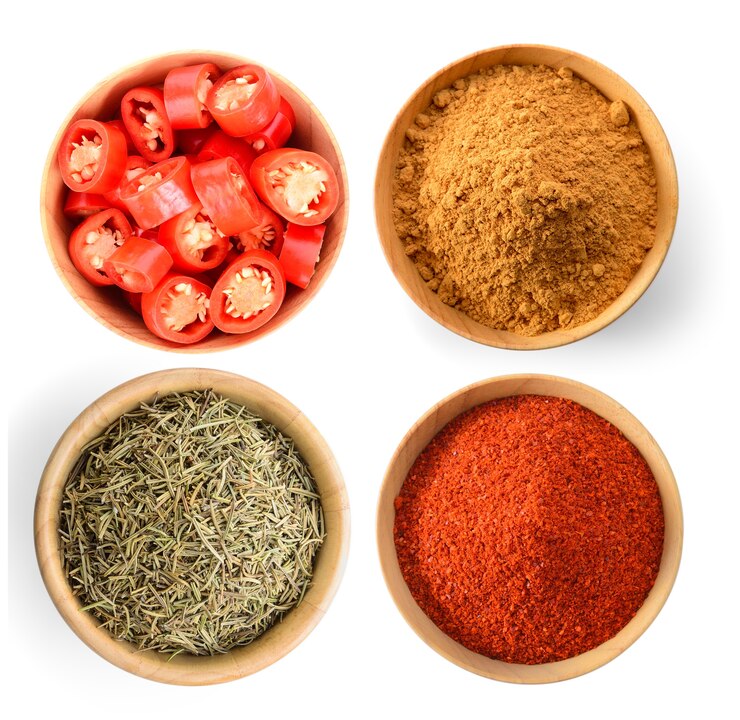 Zdjęcie chili plasterek, pieprz cayenne, suszone liście rozmarynu, cynamon w proszku na białym tle