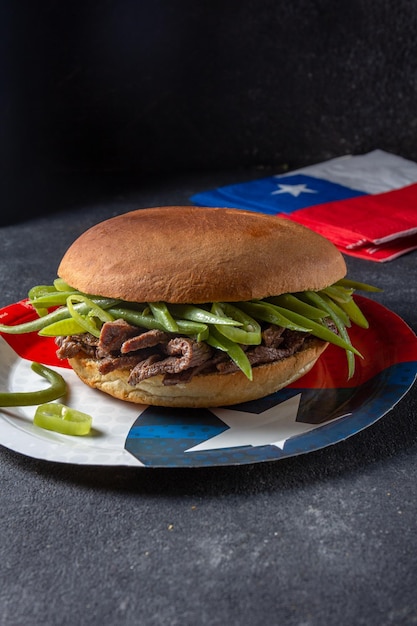 Chilijski burger kanapkowy z Ameryki Łacińskiej Chacarero z plastrami wołowiny premium i zieloną fasolką na czarnym tle