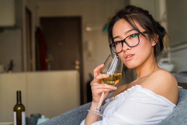 Chinka samotnie pijąca wino w domu