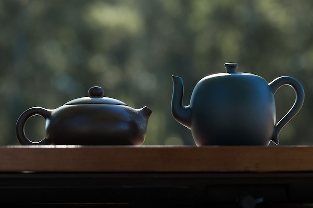 Chińska ceremonia parzenia herbaty. Czajnik ceramiczny wykonany z gliny i miski na drewnianym tle.