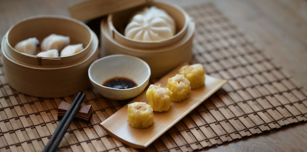 Chińska kluska gotowana na parze i wieprzowina na parze w bambusowym parowcu z chopstick na drewnianym stole