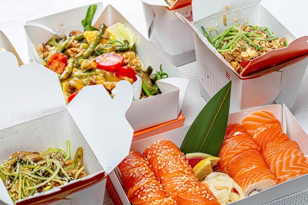 Zdjęcie chińskie jedzenie w kartonowym pudełku sałatka sushi makaron ryż