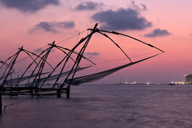 Chińskie sieci rybackie na zachodzie słońca Kochi Kerala Indie