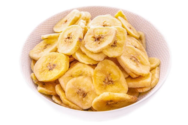 Chipsy bananowe w białym talerzu na białym tle, pojedyncze produkty