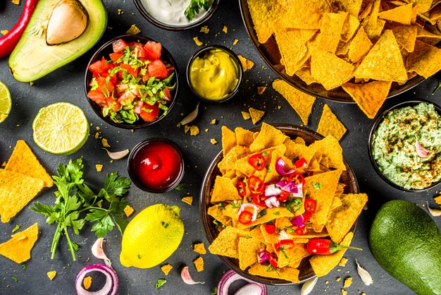 Chipsy nachos z różnymi dipami, tradycyjna meksykańska przekąska na talerzu
