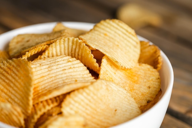 Chipsy ziemniaczane w misce dobre na przekąskę do piwa lub piwa na naturalnym drewnianym stole Dobre na reklamę restauracji pubowej festiwalu piwa