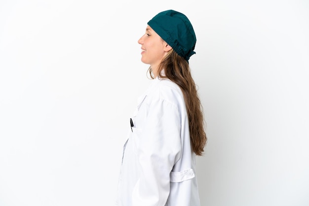 Chirurg kaukaski kobieta w zielonym mundurze na białym tle śmiejąca się w pozycji bocznej