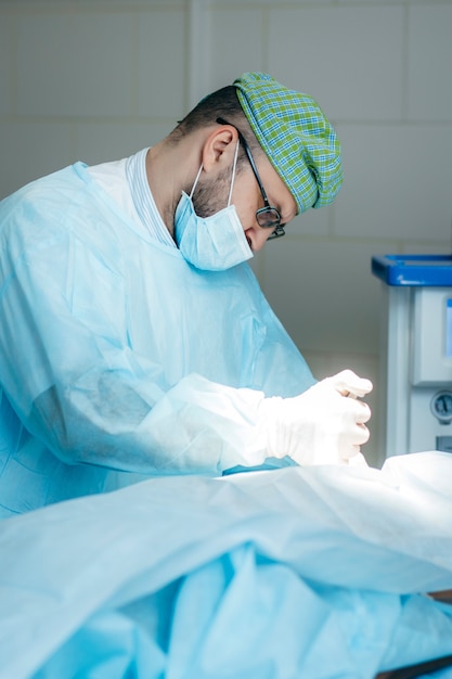 Chirurg Wykonujący Operację Piersi W Szpitalnej Sali Operacyjnej. Chirurg W Masce Noszący Lupy Chirurgiczne Podczas Zabiegu.
