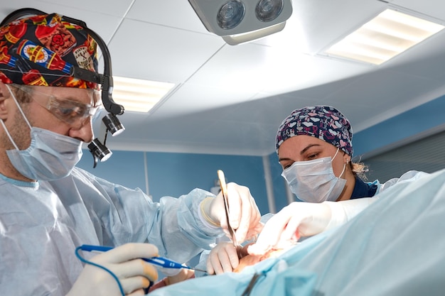Chirurg z asystentem operuje w kobiecej mammoplastyce piersi onkologicznej