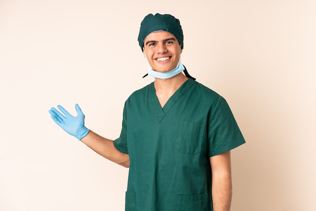 Chirurga mężczyzna w błękita mundurze nad odosobnionym tła mienia copyspace imaginacyjnym na palmie