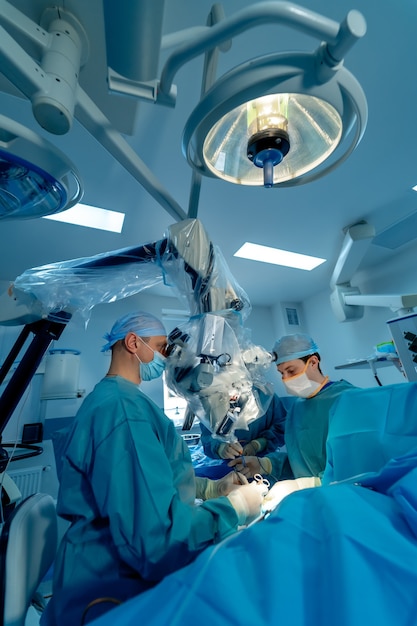 Chirurgia kręgosłupa. Grupa chirurgów w sali operacyjnej ze sprzętem chirurgicznym. Lekarz patrząc na ekran. Nowoczesne wykształcenie medyczne