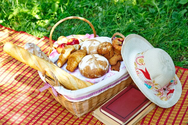 Chleb, bagietka i rogaliki w koszyku piknikowym