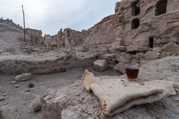Zdjęcie chleb i drinka na skale w pobliżu starych ruin