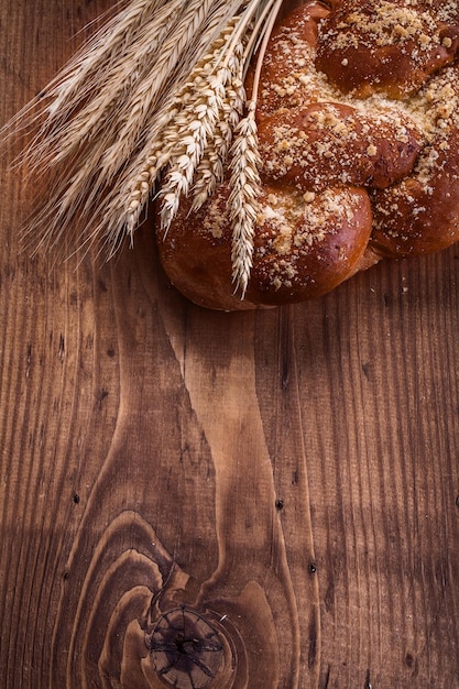 Chleb i pszenica uszy na drewnianej desce koncepcja jedzenie i picie