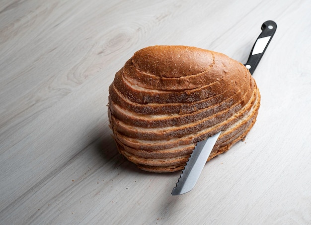 Chleb mózgowy pokrojony w plasterki nożem na szarym stole