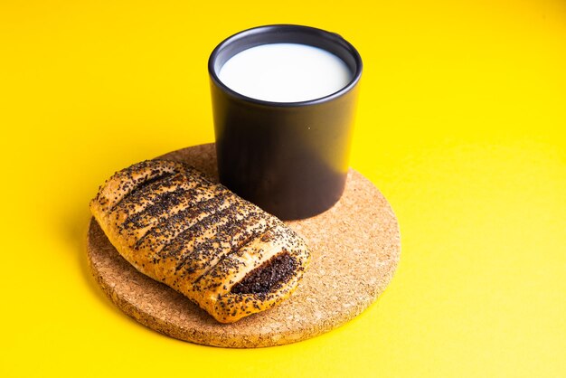 Chleb śniadaniowy i filiżanka mleka na żółtym i niebieskim tle