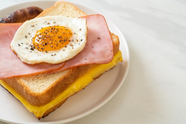 Chleb, toast, ser, szynka i smażone jajka z kiełbaską wieprzową.