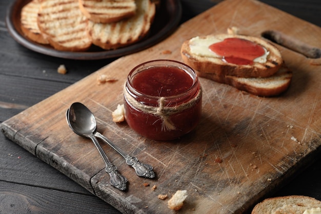 Chleb tostowy z domowym dżemem truskawkowym i na rustykalnym stole z masłem na śniadanie lub brunch