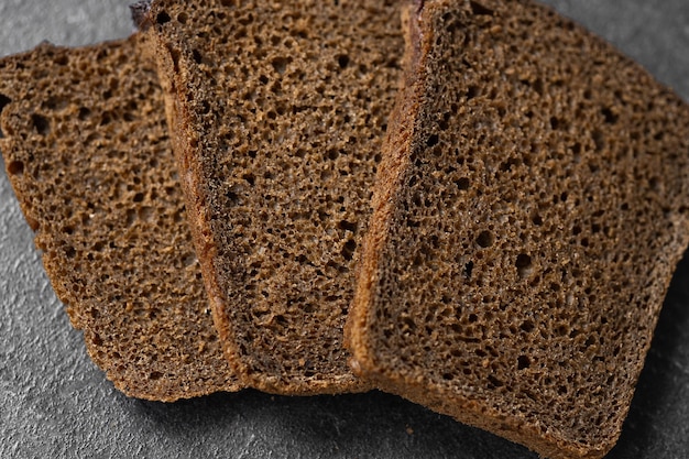 Chleb tradycyjny chleb na zakwasie pokrojony w plasterki na rustykalnym drewnianym tle