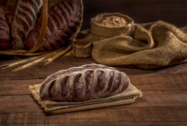 Chleb z kakao i czekolady na rustykalnym suknem na rustykalnym drewnianym stole ze składnikami.