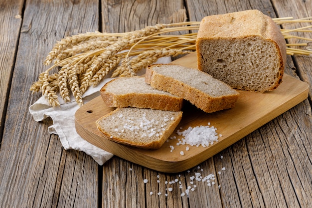 Chleb żytni jest krojony na kawałki na desce do krojenia