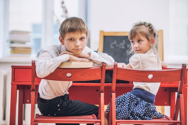 Zdjęcie chłopak, dziewczynki w szkole są szczęśliwe, ciekawe, mądre. edukacja, dzień wiedzy, nauka, pokolenie, przedszkole.