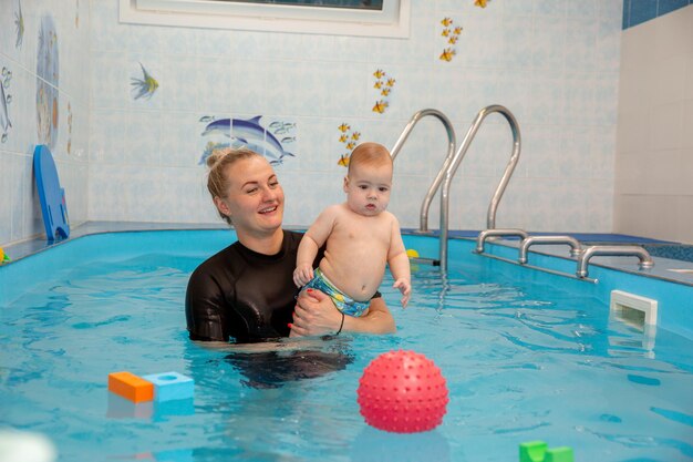 Chłopczyk trenuje pływanie w basenie z trenerem