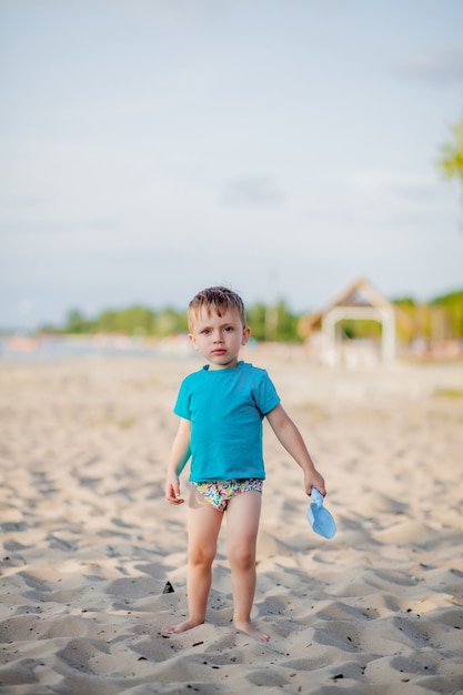 chłopiec bawi się na plaży dziecko bawi się na morzu na letnich rodzinnych wakacjach zabawki z piasku i wody ochrona przed słońcem