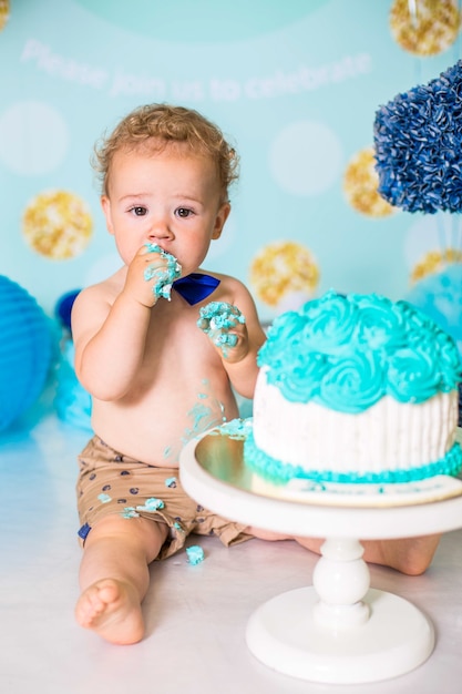 Chłopiec bawi się tortem podczas przyjęcia urodzinowego Cake Smash