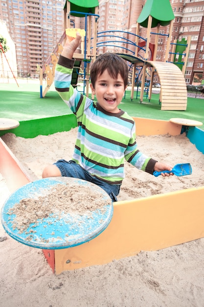 Chłopiec bawi się w piaskownicy