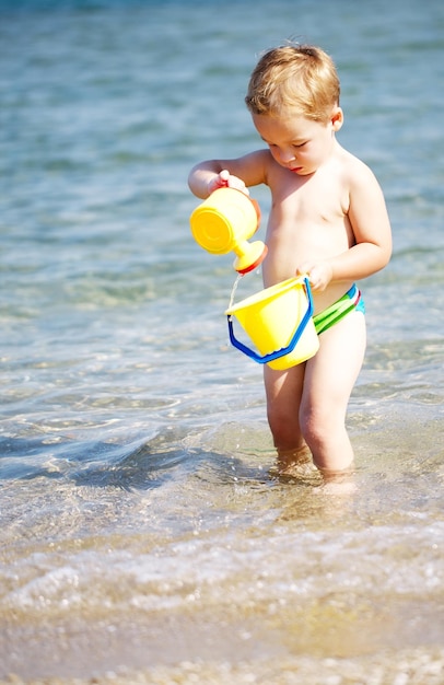 Chłopiec bawiący się zabawkami na plaży