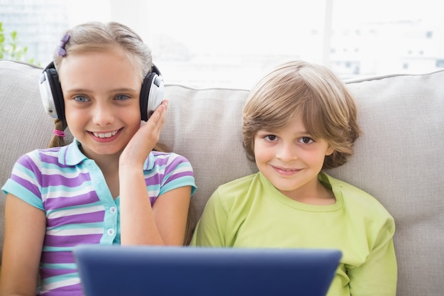 Chłopiec bawić się muzykę na laptopie dla siostry w żywym pokoju