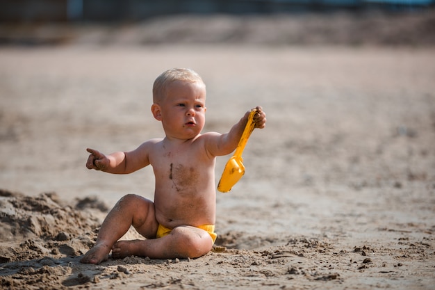 Chłopiec bawić się z piaskiem morzem